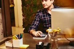 Smiling man sitting behind his desk.