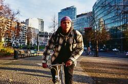 Cycling man, autumn trees and office buildings on the background.