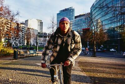 Cycling man, autumn trees and office buildings on the background.