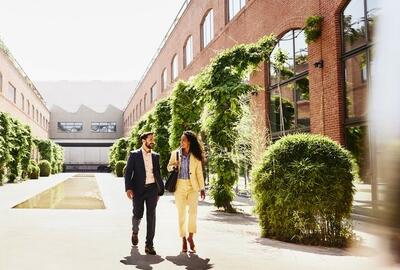 Man and woman walking outside between office buildings.