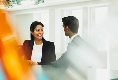Smiling woman and man talking at the office