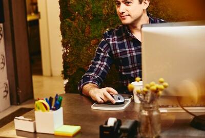 Smiling man sitting behind his desk.