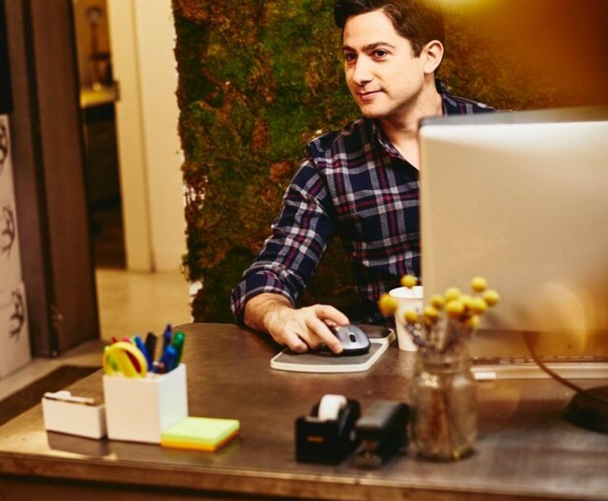 Smiling man sitting behind his desk.