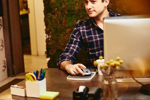 Smiling man sitting behind his desk.