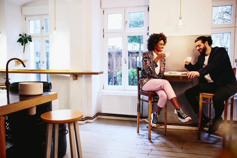 man and wonan discussing work over coffee