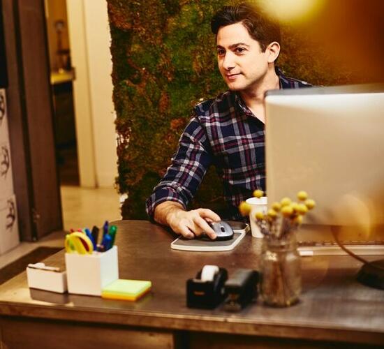 Smiling man sitting behind his desk.