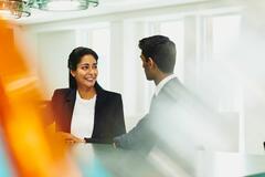 Smiling woman and man talking at the office