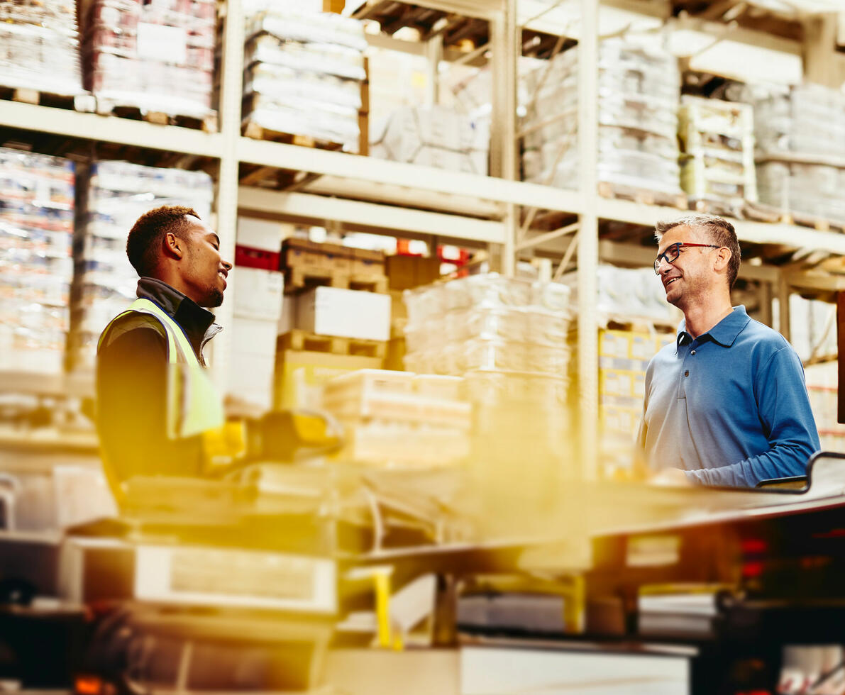 Two men talking in a warehouse