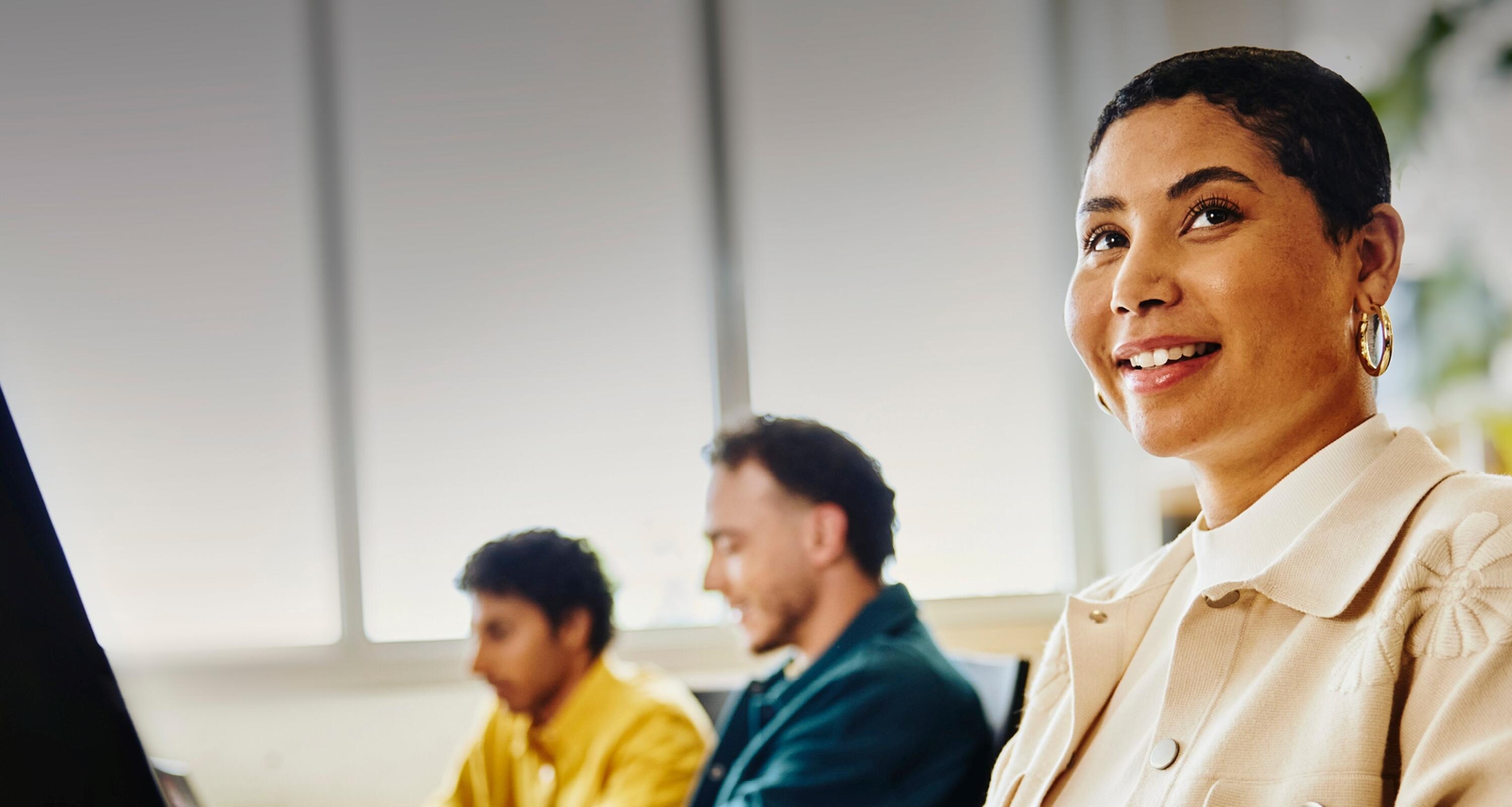 young woman behind her computer smiling