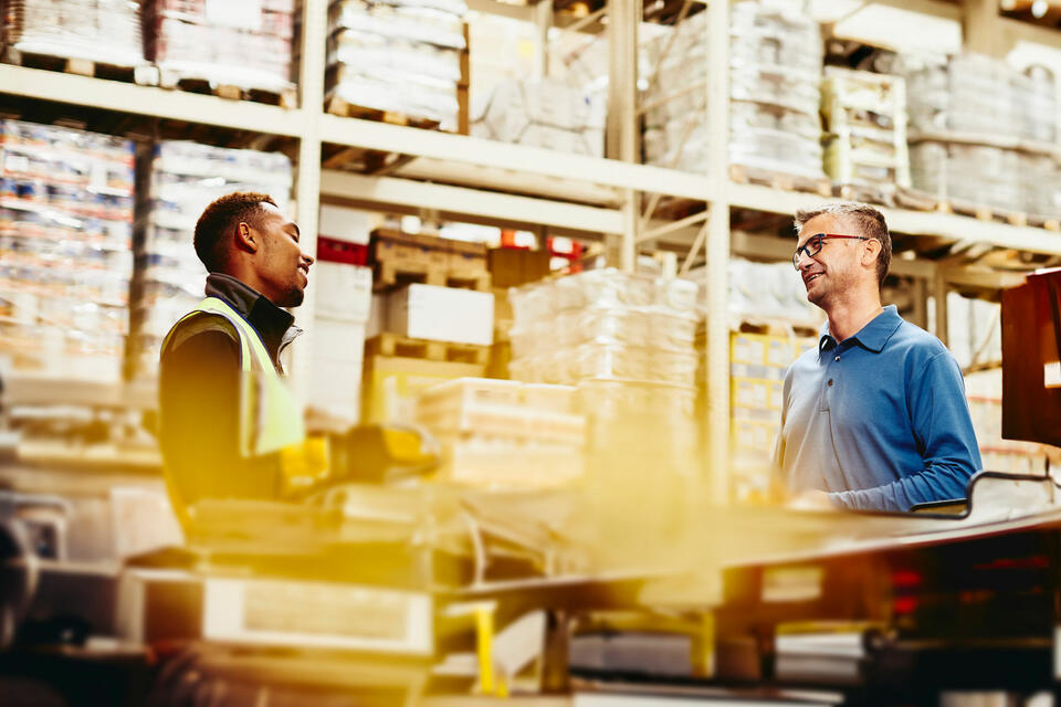 Two men talking in a warehouse